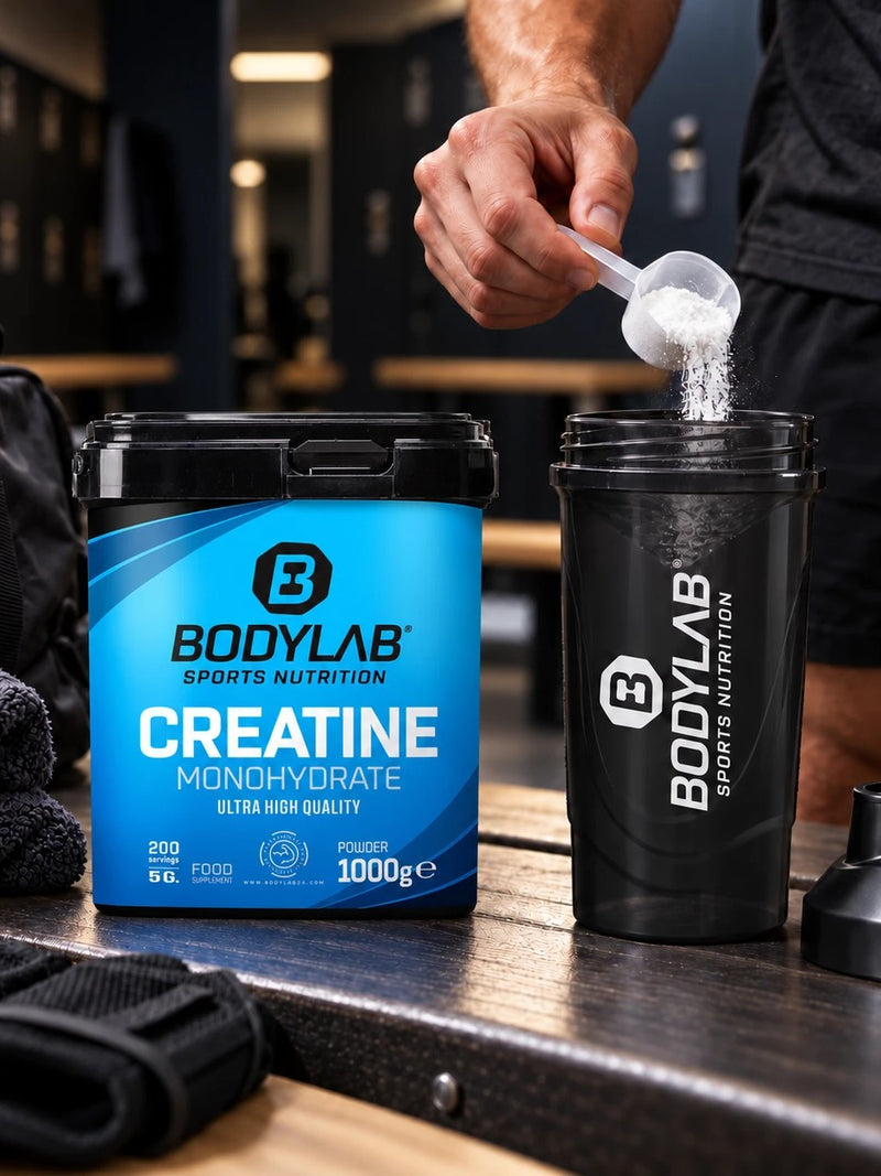 In der Umkleide wird ein Messlöffel Kreatin in den BODYLAB Shaker gegeben, daneben die BODYLAB Creatine Monohydrate Dose